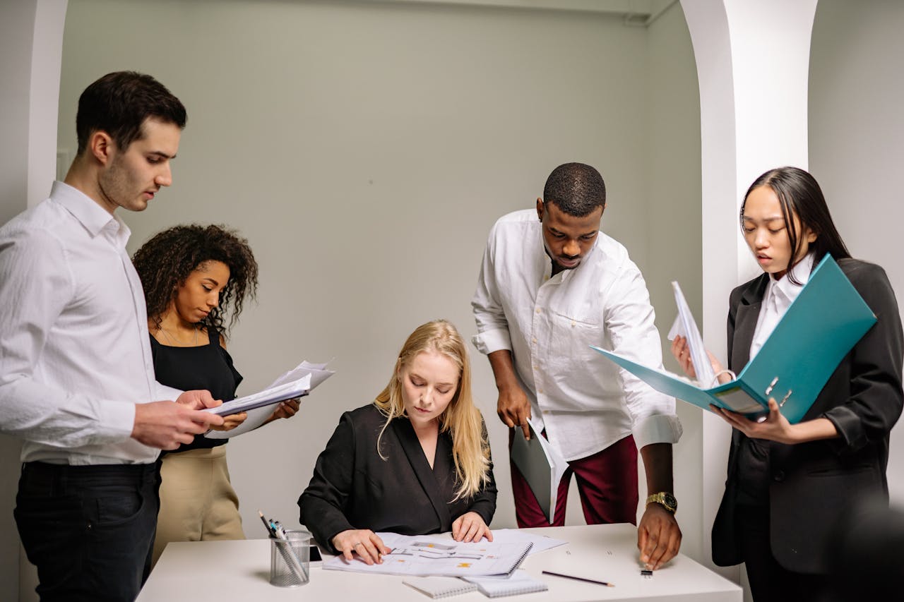 Services Diverse team working together in an office setting, reviewing documents and collaborating on projects.